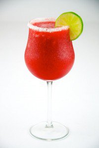 Strawberry Daiquiri with lime in a hurricane glass on a salted rim